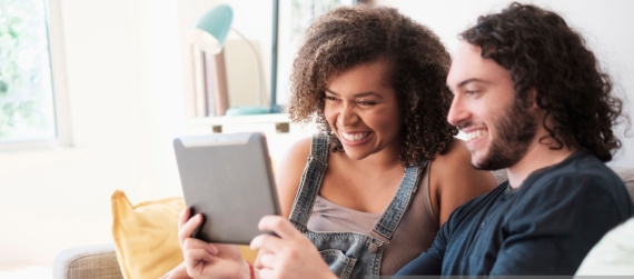 Couple looking at tablet laughing