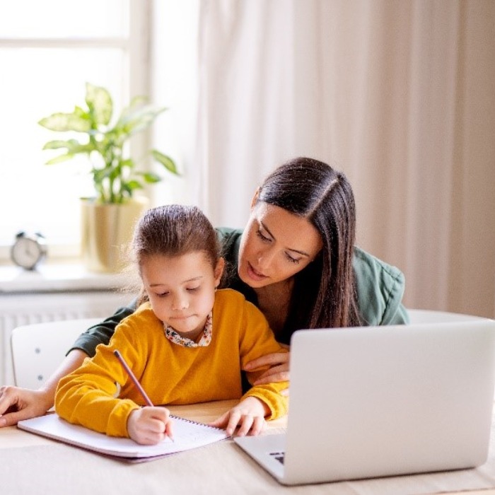 Mum teaching daughter at table